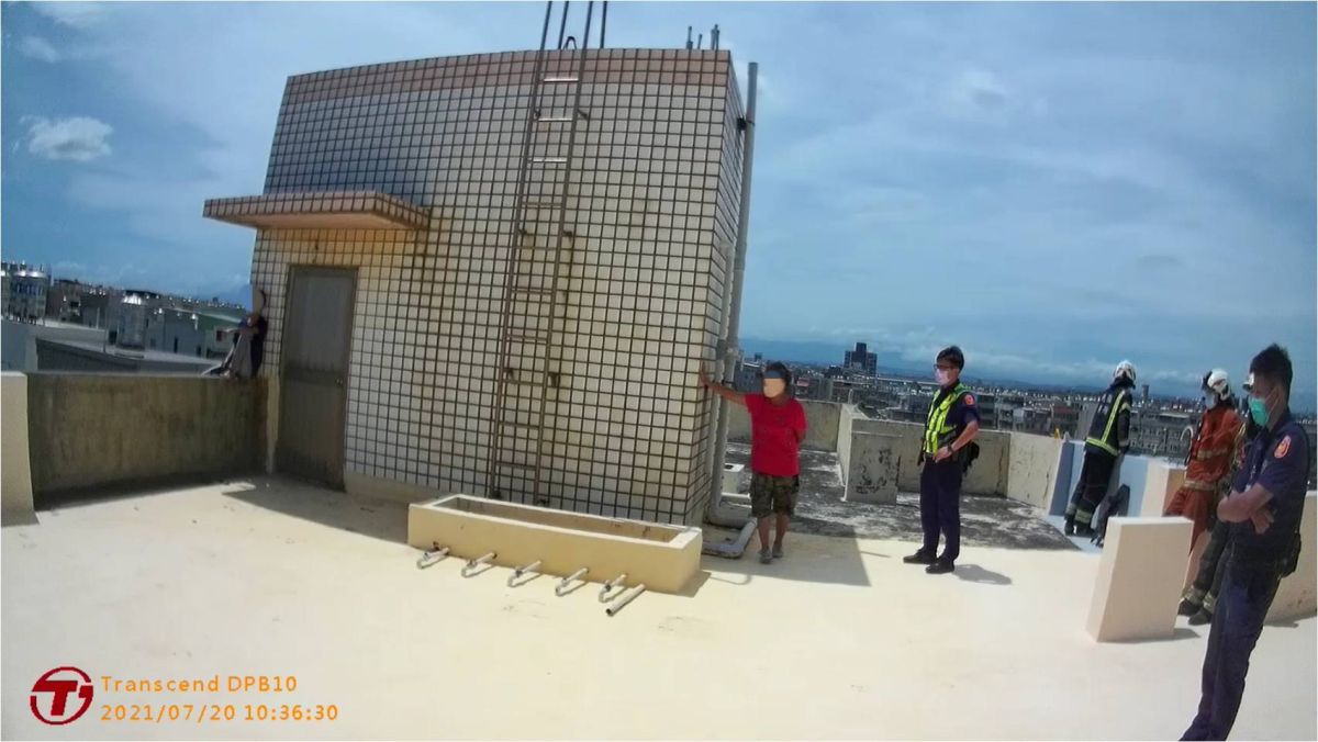 ▲呂女情緒突然失控，持刀衝上頂樓坐在圍牆邊欲跳樓，員警立即跟上勸阻。（圖／大園提供）