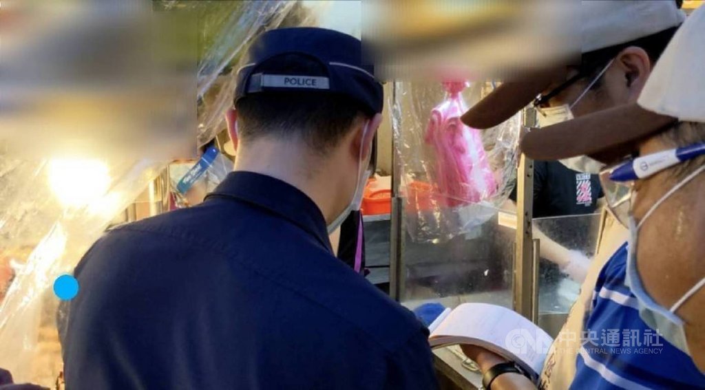 ▲基隆市政府28日晚間針對廟口和愛四路夜市展開防疫聯合稽查，愛四路一間攤商未依防疫指引配戴面罩，經規勸後仍未改善，稽查人員當場開出復市後首張告發單，將移請衛生局裁罰。（圖/中央社）