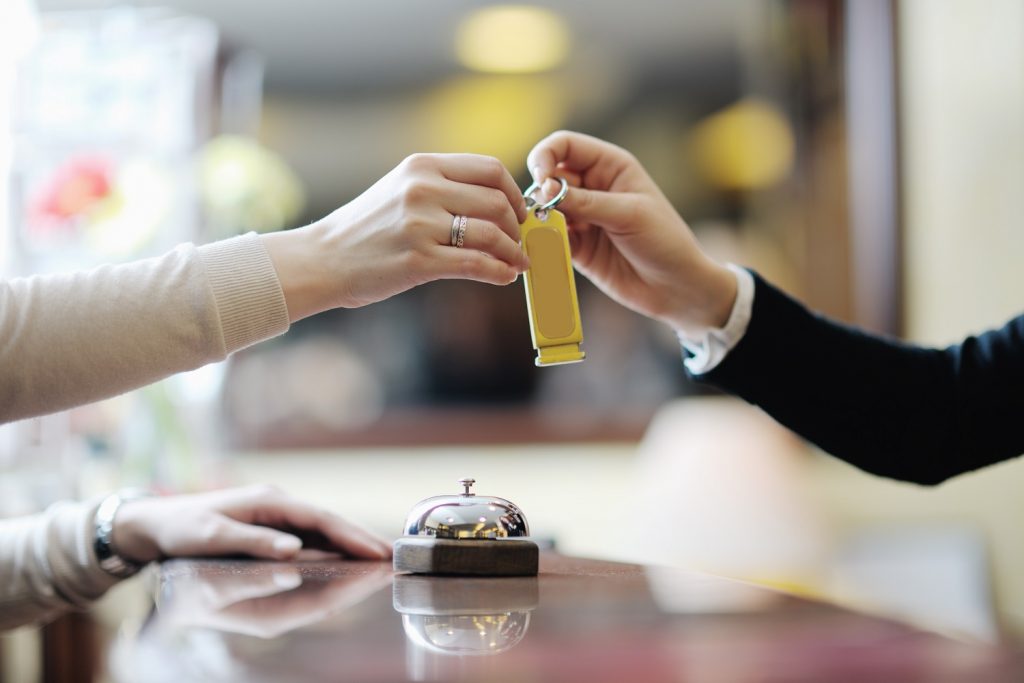 ▲櫃台小姐將房卡遞上桌面，「祝您有個美好的夜晚。（圖／Shutterstock）