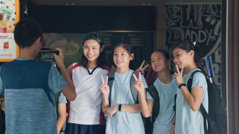▲當有「學妹」上前邀請戴資穎合照,戴姊看著小戴與小球員的身影,想起小時候練球時的往事。(圖/擷取自《在你身邊為你加油,這樣的滋味,真好》)