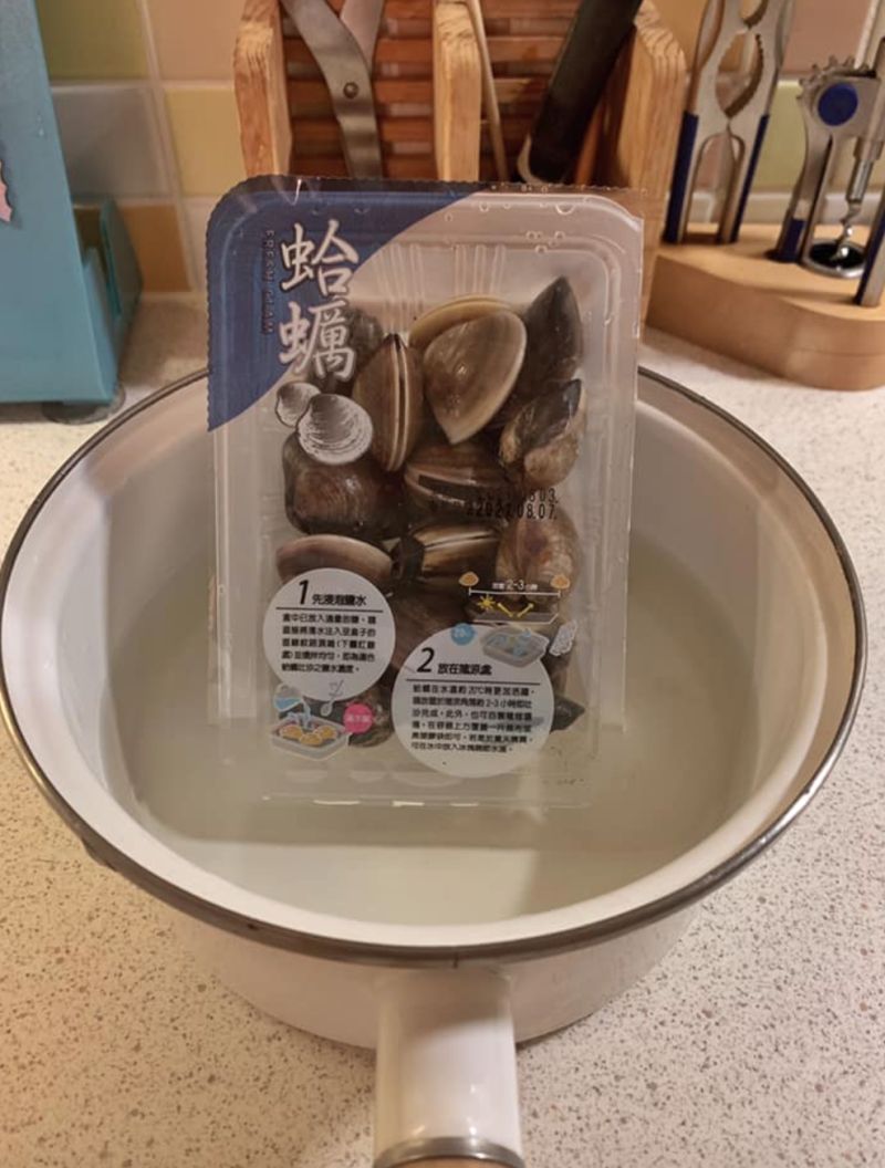 ▲原PO女兒將蛤蜊拿出來「泡在一個裝水的鍋子裡」,不但沒有將蛤蜊從塑膠盒中倒出,還直立著放。(圖/翻攝自《Costco好市多