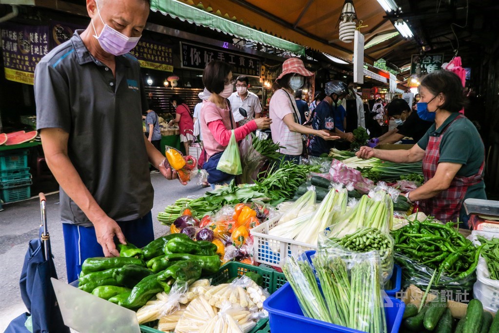 ▲受8月上旬連日豪雨影響，近期葉菜供應量少價昂，14日傳統市場菜價仍偏高，民眾在攤販前仔細選購蔬果。(圖/中央社）