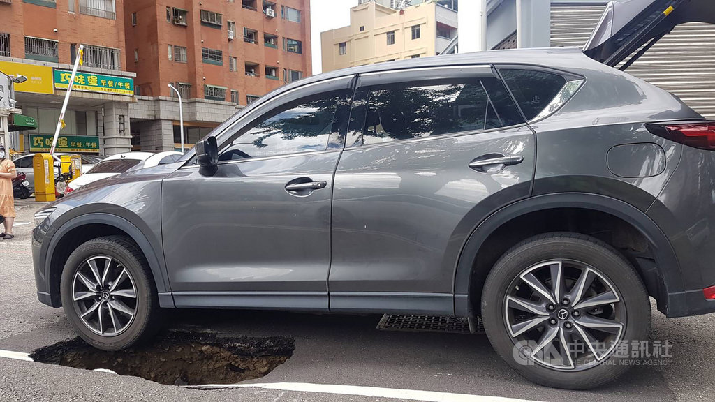 ▲台中市南區忠明南路路面14日出現一處坑洞，一輛休旅車左前輪陷入，警方到場發現坑洞位於慢車道路面，還好休旅車最終順利移出，沒有人員受傷。（圖/中央社）