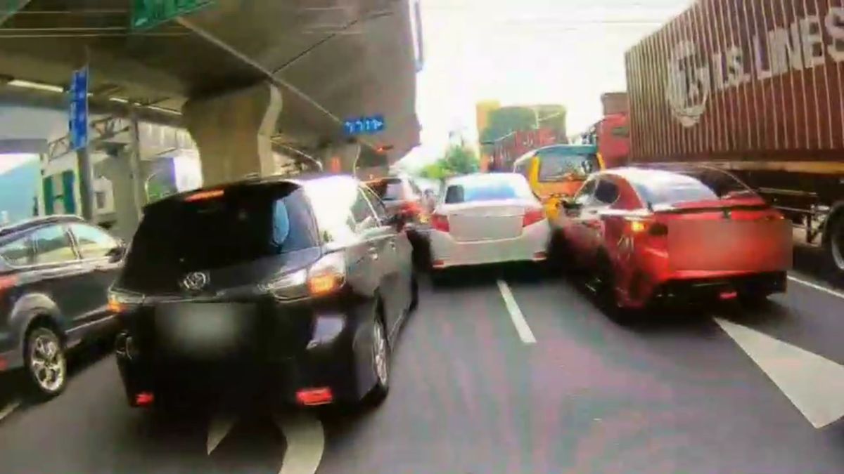 ▲嫌犯駕駛的白色自小客車加速逃逸，從兩車道中間狹窄的間隙一路向前疾駛，衝撞警用機車等10車。（圖／翻攝畫面）