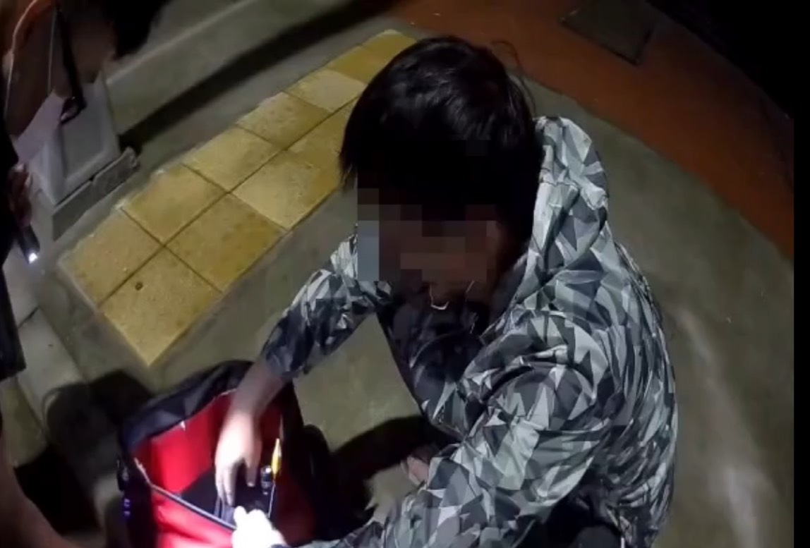 ▲鄭嫌經過警方苦言相勸，終於主動打開包包。（圖／翻攝畫面）