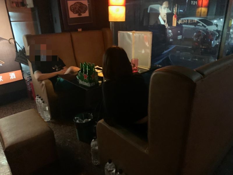 ▲沈姓負責人見到警方突擊進入店內實施防疫稽查時,一度將放在地上的透明隔板拿到桌上放置,但警方早已全程錄影蒐證。(圖/記者郭凱杰翻攝)