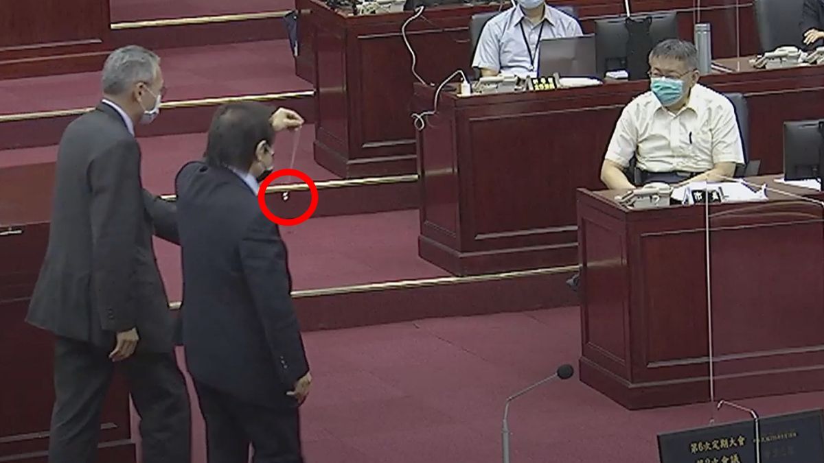 ▲民進黨台北市議員王世堅（左2）在台北市長柯文哲（右1）施政報告前，送上玩具「魔戒」提醒柯文哲「權力就像魔戒，一戴上去就脫不下來。」（圖／翻攝台北市議會直播）