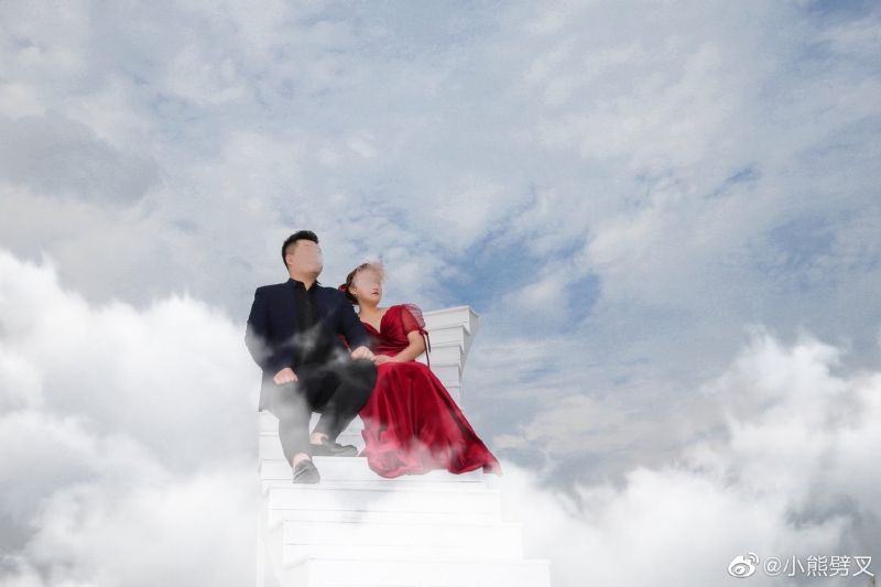 ▲新郎與新娘坐在階梯上，背景則配上藍天白雲，看起來十分荒謬。（圖／翻攝自《小熊劈叉》微博）