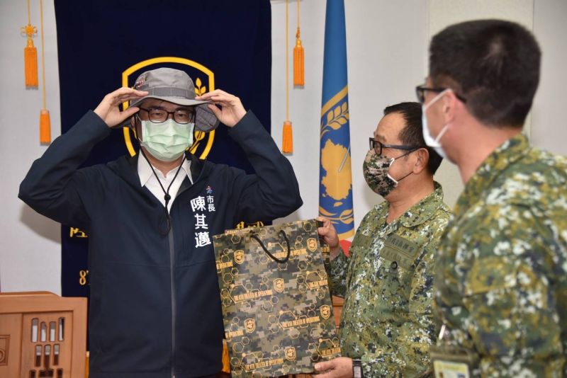 ▲八軍團中將指揮官傅正誠回贈軍方野戰帽，及繪印陳其邁勘災木製雷雕紀念品。（圖／高市府提供）