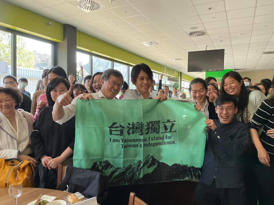 ▲駐德代表謝志偉在國慶日舉起上有中文「台灣獨立」四個大字的布條。（圖／取自「謝志偉粉絲頁）