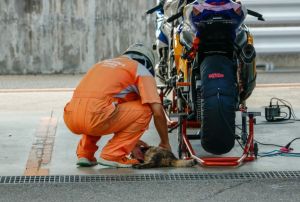 ▲一位技師正忙著維修車子，但虎斑貓硬要躺在車子旁超礙事！（圖／twitter@lim_MT25）