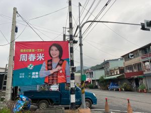 ▲周春米在原鄉掛出穿有原住民傳統服飾的看板，以爭取更多民眾支持。（圖／記者黃宣尹攝影）