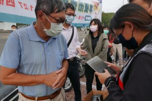 ▲為使第二波商圈夜市圈發放更順暢，民眾排隊時，由行動服務人員用平板驗證身分證號，及拍照民眾將兌換的振興券與證件留存。（圖／高雄市經發局提供）