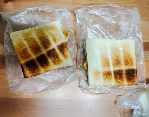 原PO貼出的餐點除了餡料剖半外,吐司外觀也焦黑。(圖/《爆怨公社》) ▲原PO貼出的餐點除了餡料剖半外,吐司外觀也焦黑。(圖/《爆怨公社》)