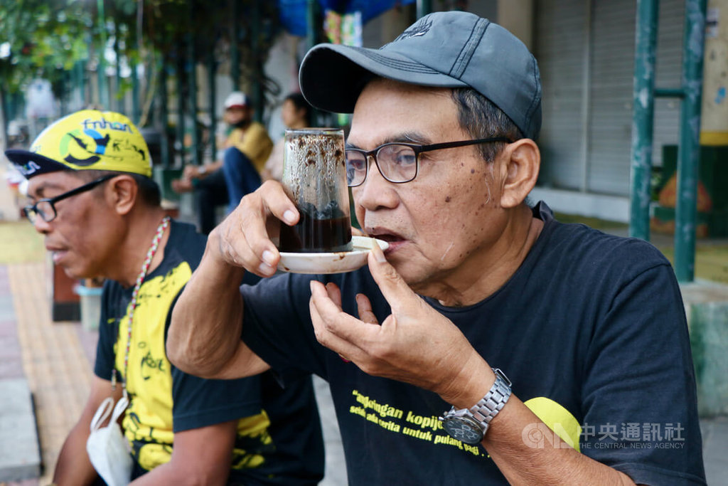 ▲印尼中爪哇古都日惹特有的Kopi Joss深受當地人喜愛，忠實老客戶西斯沃示範Kopi Joss的喝法。攝於110年10月14日。中央社記者石秀娟日惹攝 111年2月2日
