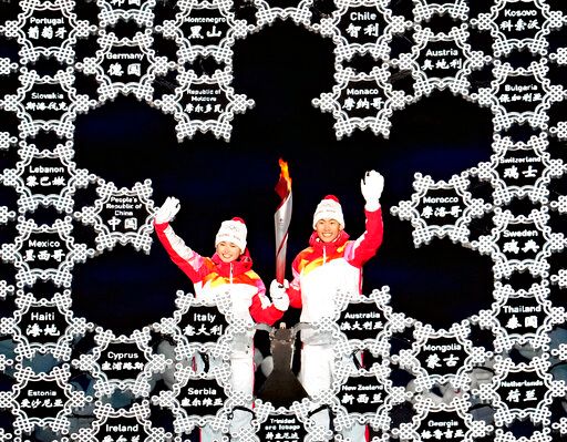 ▲2022年冬奧會開幕式上，中國安排新疆運動員衣拉木江（左）和趙嘉文點燃冬季奧運聖火。（圖／美聯社／達志影像）