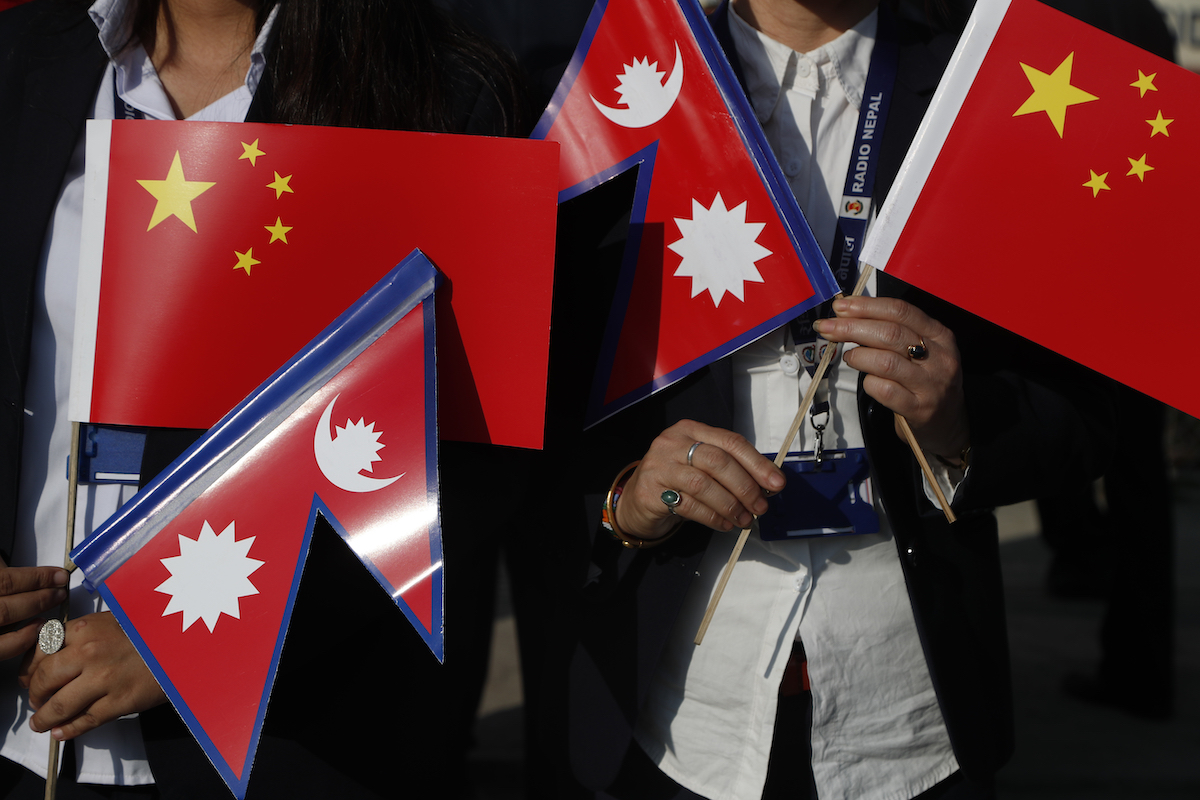 ▲尼泊爾與中國一直以來存在邊境問題。圖為2019年尼泊爾政府官員拿著兩國國旗迎接中國國家主席習近平來訪。（圖／美聯社／達志影像）