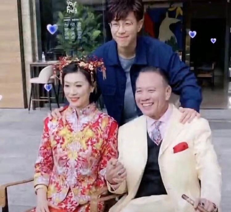 ▲萬梓良(右)和老婆郭明黎十指緊扣拍婚照,18歲兒子站在後面開心合影。(翻攝微博)