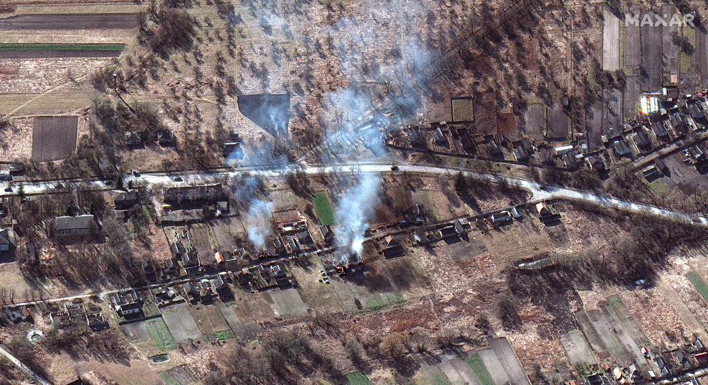 ▲烏克蘭伊萬基夫（Ivankiv）區的東北方，集結了大量裝甲車地面部隊，還能看見房子在燃燒。（圖／美聯社）
