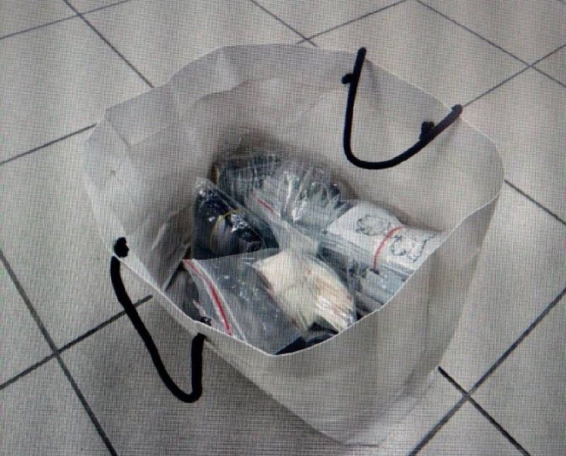 ▲嫌犯的白色紙袋內裝滿200多包的毒品。（圖／翻攝畫面）