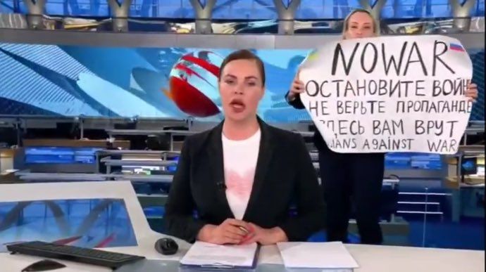 ▲俄羅斯國營電視台第一頻道在直播新聞時，遭到一名女性持反戰標語闖入。（圖／翻攝自推特）
