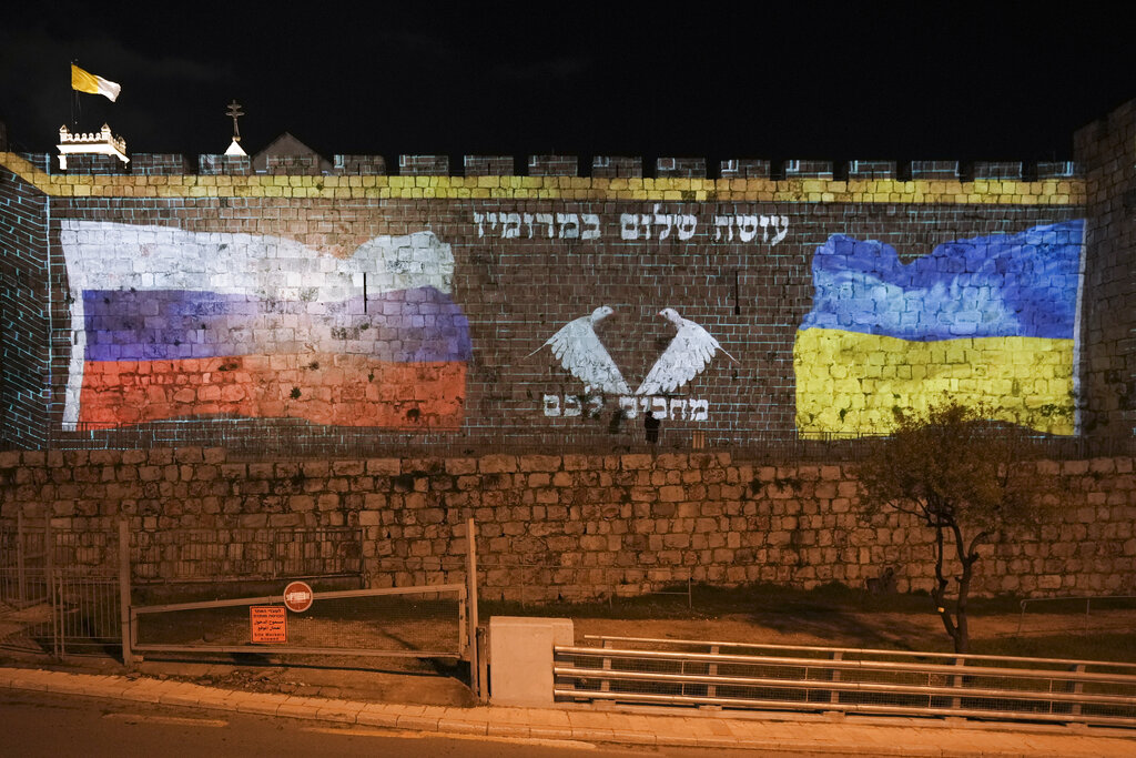 ▲克里姆林宮今天表示，歐洲聯盟決定授予親西方的烏克蘭正式的歐盟候選國資格，這是歐洲的「內部」事務。圖為投影在以色列耶路撒冷牆上的俄羅斯國旗與烏克蘭國旗，中間以希伯來文寫下「祈禱和平」。（圖／美聯社／達志影像）