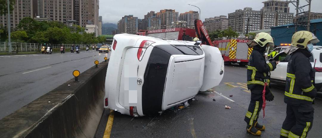 ▲白色小轎車翻覆路中，造成現場一度回堵。（圖／翻攝畫面）