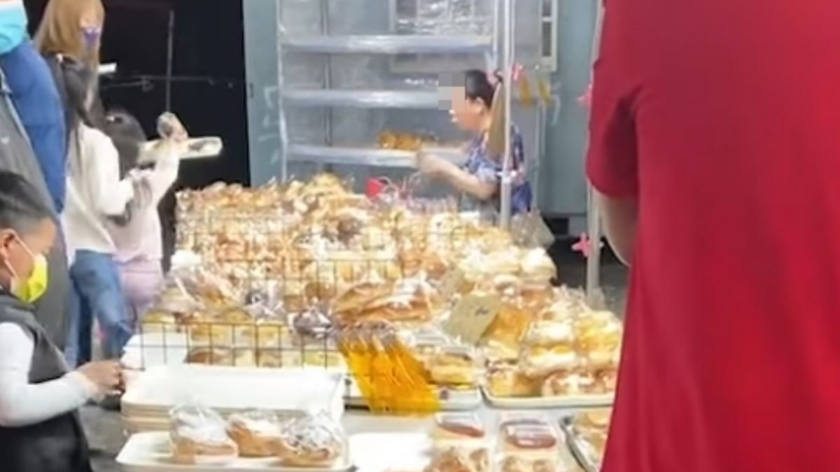 ▲有網友拍下某夜市麵包攤商，女員工無罩吹麵包。（圖／爆料公社）