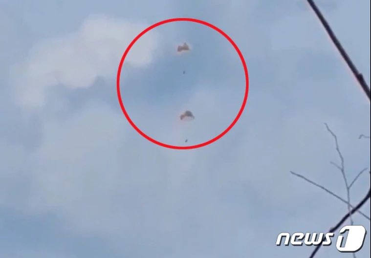 ▲KT-1戰機相撞後，飛行員使用降落傘逃生。（圖／翻攝自NEWS1）