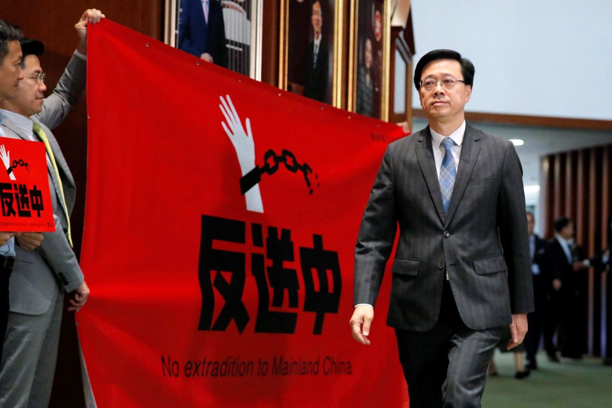 ▲香港政務司司長李家超宣布辭職並競選特首一職。圖為2019年反送中期間，李家超從手持抗議標語的民主派議員面前走過。（圖／美聯社／達志影像）