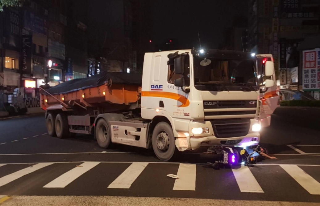 ▲黃姓機車駕駛倒地後被壓在車頭下，險些遭輾斃。（圖／翻攝畫面）