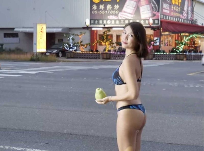 ▲近日網路上瘋傳一段影片，影片中一名比基尼女子穿著火辣站在馬路邊，手拿一顆芭樂叫賣。（圖/百大SG YT頻道）