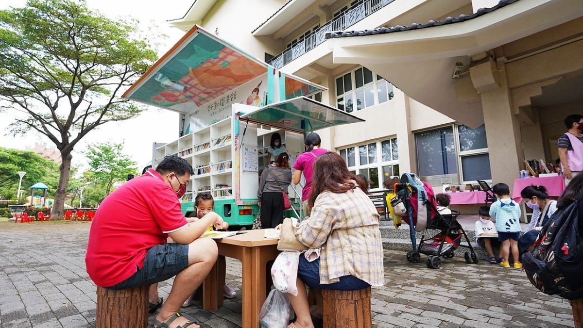 ▲「世界閱讀日」高市圖集結五輛行動圖書車至四間圖書分館停駐展翼，吸引當地親子至圖書館前戶外閱讀。（圖／高市圖提供）