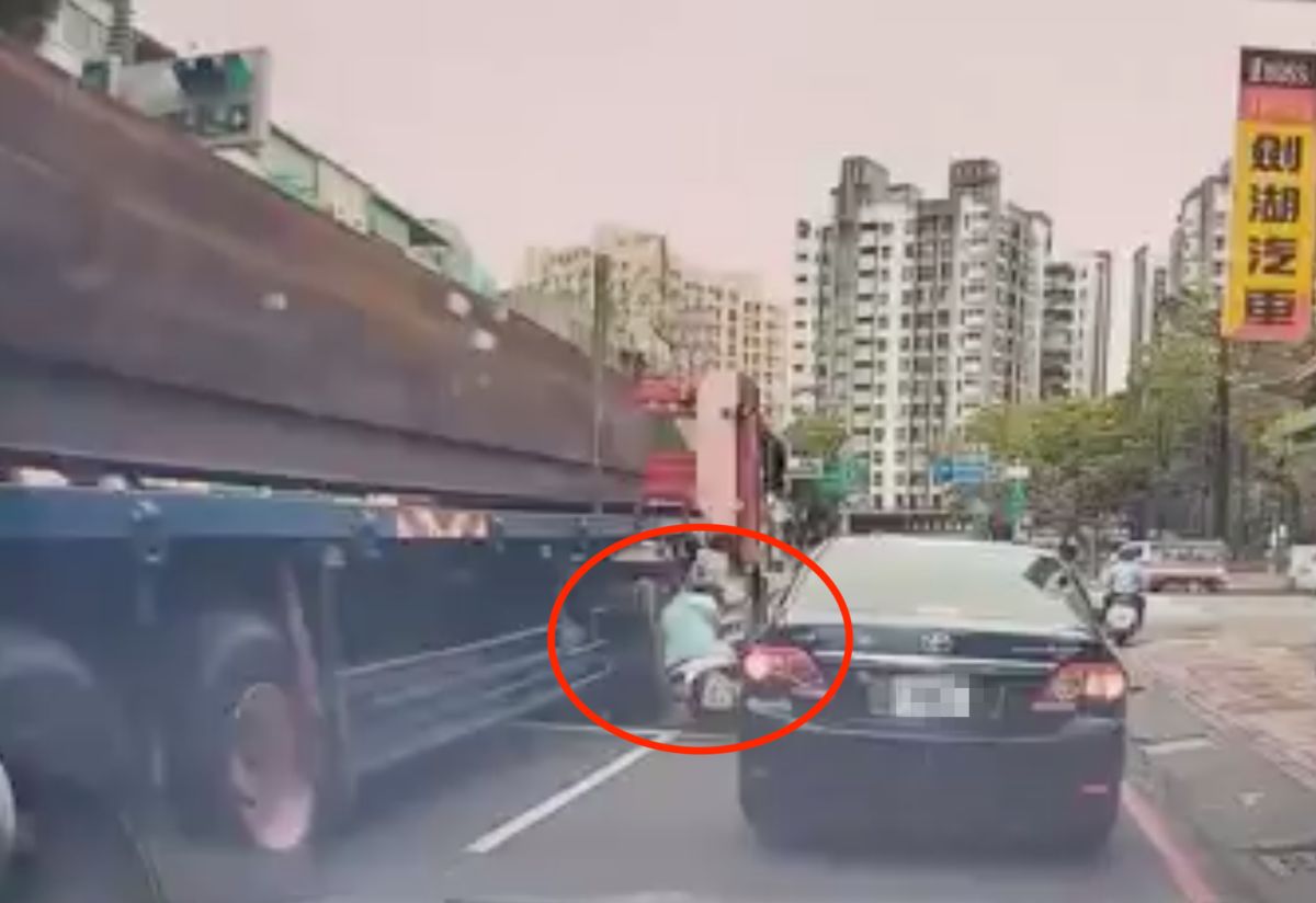 ▲高雄市三民區今（3）日上午11點多發生一起驚悚車禍，一位女騎士騎車行經九如一路與正義路口，從轎車與聯結車之中鑽過時，重心不穩摔倒跌落在一旁的聯結車下。聯結車直行從吳女身旁輾過，畫面看來驚險萬分。（圖／翻攝自爆料公社臉書）