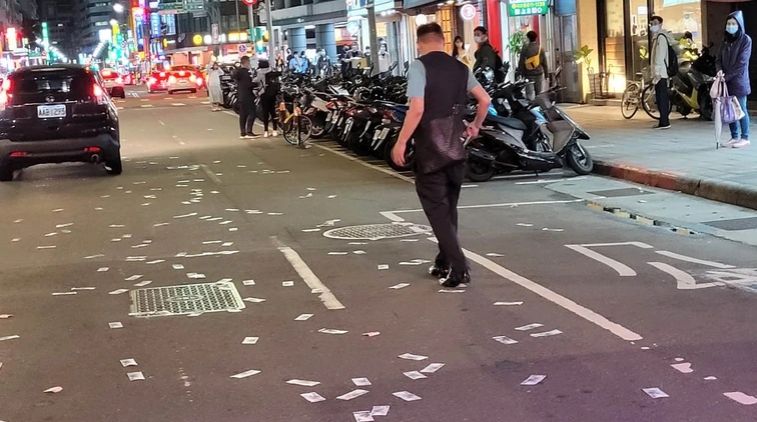 ▲張男不明原因站在車道上大吼大叫,並狂撒3、4萬元。(圖/翻攝臉書我們是新店人!! 好山好水,就是愛新店)