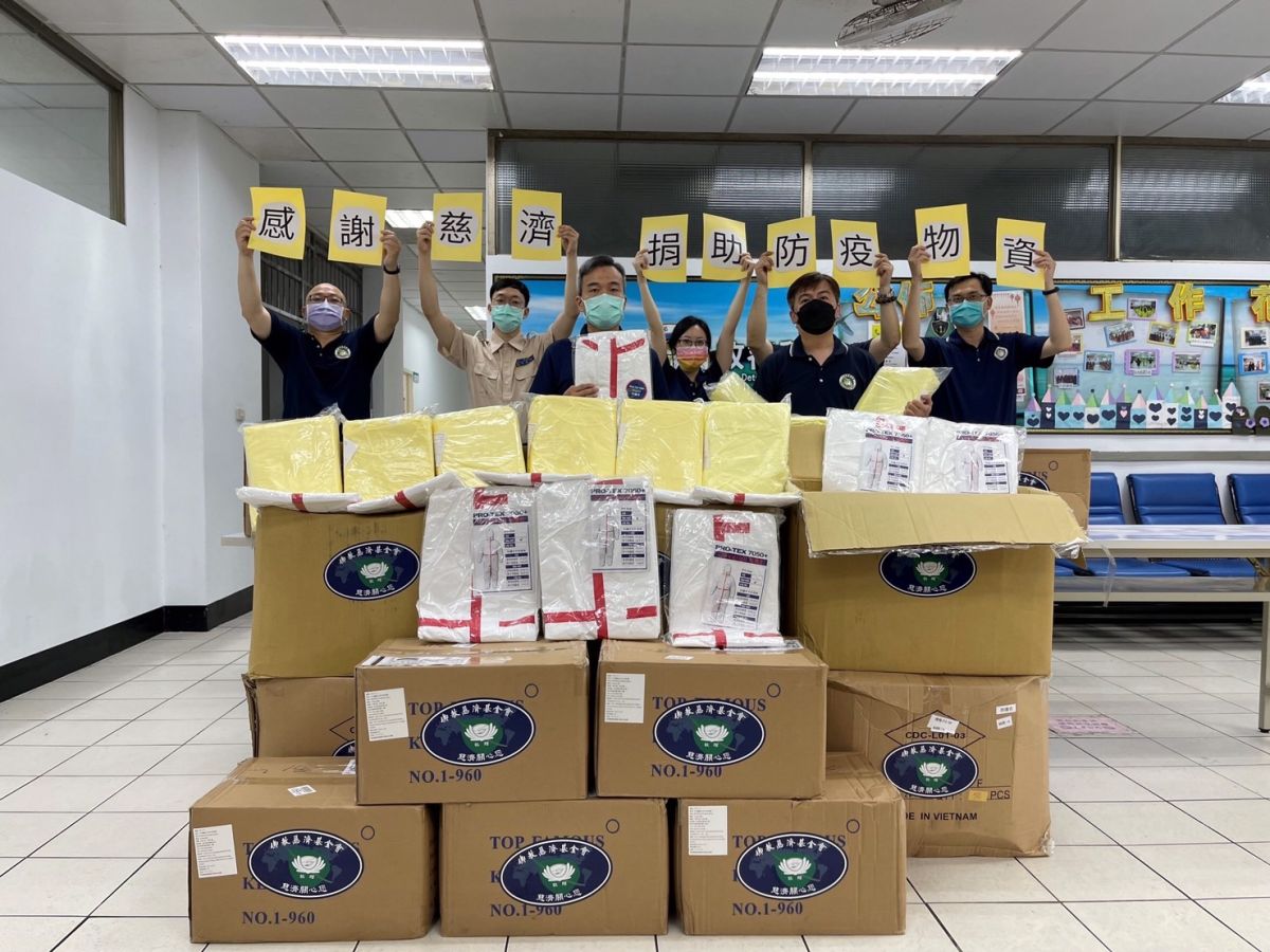 ▲移民署臺北收容所所長蔡培源（前排中）與同仁高舉字卡感謝慈濟捐助防疫物資（圖／移民署提供）