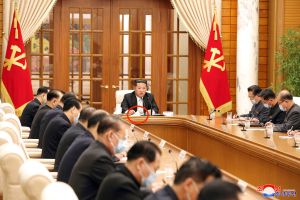 北韓疫情 ▲金正恩進入會議室後將口罩拿下擺在桌上(紅圈處),官媒拍完照後又戴上主持會議。(圖/美聯社/達志影像)