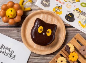 皇上是芒果口味?甜甜圈聯名「黃阿瑪」 開吃楊枝甘露 ▲「Socles甜甜圈」是香濃黑可可搭配可可鮮奶油內餡,炯炯有神的大眼為芒果巧克力片,再用優格可可醬點上精緻小巧的鼻子,75元。(圖/Mister Donut提供)(圖/Mister Donut提供)