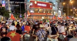 ▲越南民眾拿著國旗、騎車上街遊行慶祝。（圖／翻攝自影片）