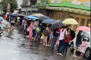 ▲為了早點打到BNT兒童疫苗，台中市家長帶著孩子在街頭冒雨排隊。（圖／台中市立德里長江和樹臉書，2022.05.27）