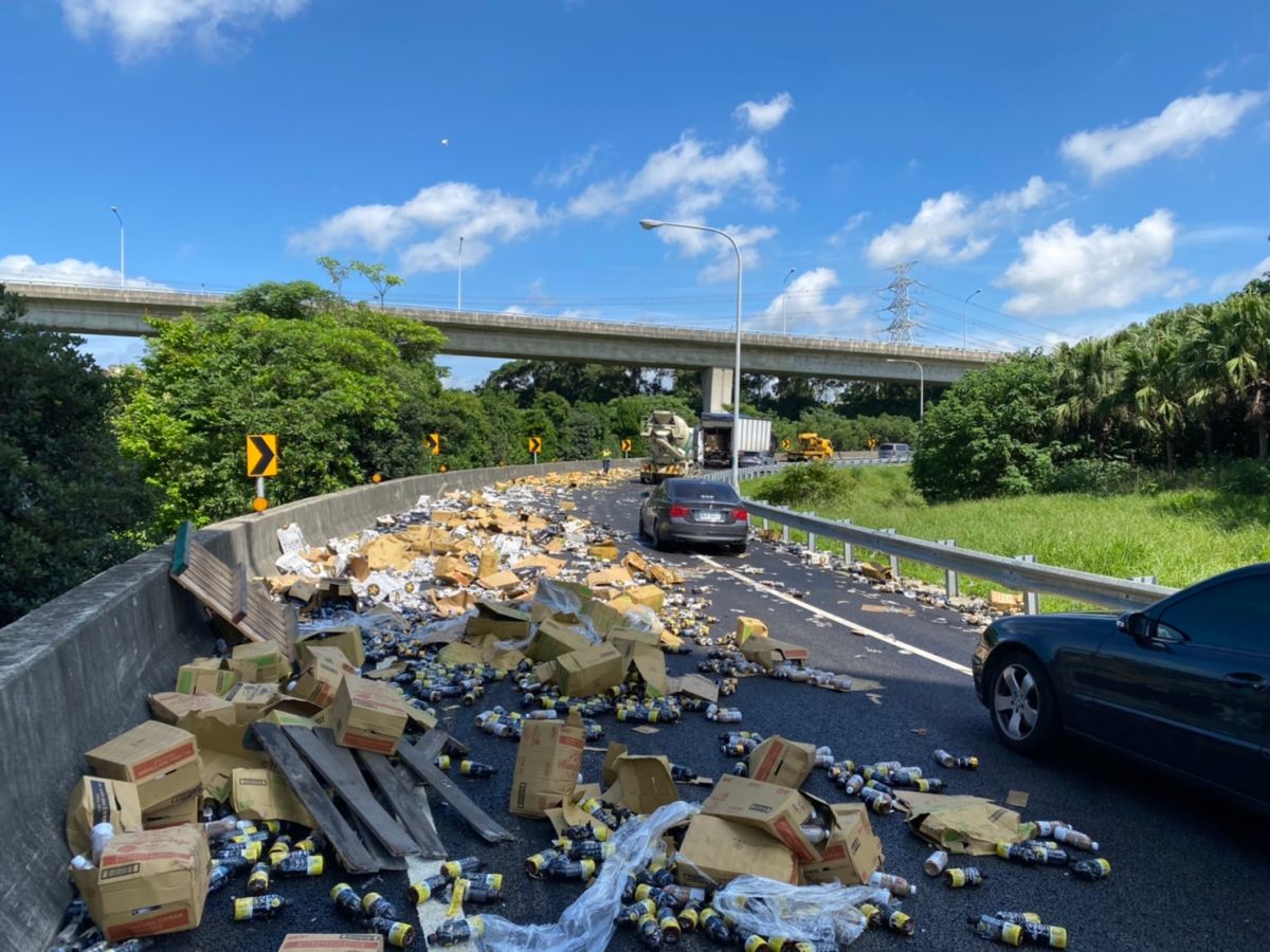 ▲貨車載運的貨物和紙箱散落一地，造成後方車輛回堵。（圖／國道警察提供）