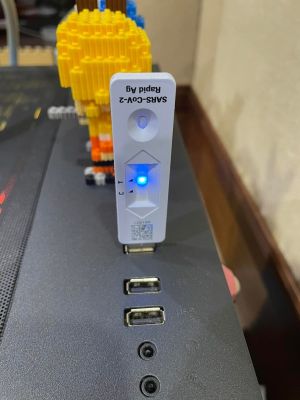 ▲沒想到插上電腦的USB插槽後，亮起的藍色燈號恰巧落在快篩試劑品管線（T）的位置，顯示正常運作中！（圖／翻攝自《爆廢公社》）
