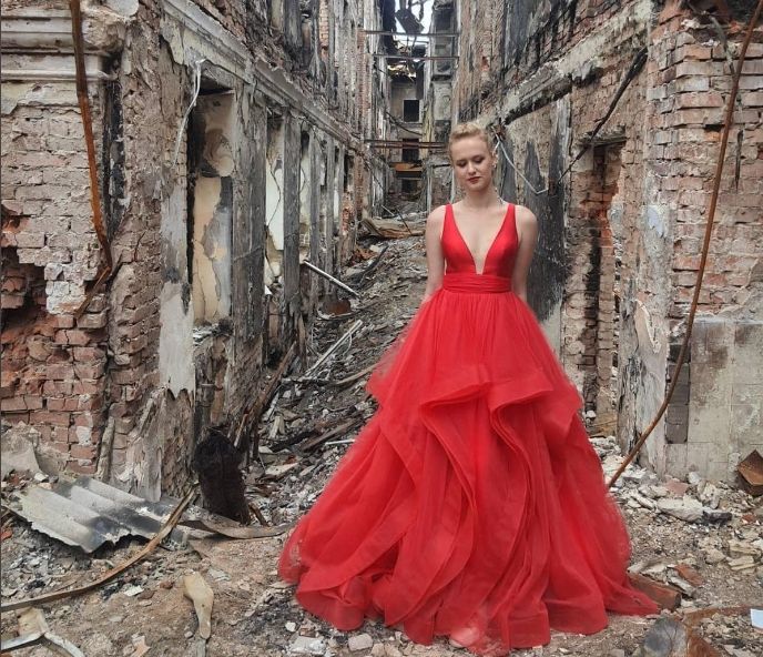 ▲加拿大多倫多的埃皮舍瓦（Anna Episheva）在推特（Twitter）分享一張她16歲侄女瓦萊麗（Valerie）穿著紅色舞會禮服，站在哈爾科夫（Kharkiv）殘破不堪校舍前的照片。（圖／翻攝自推特）