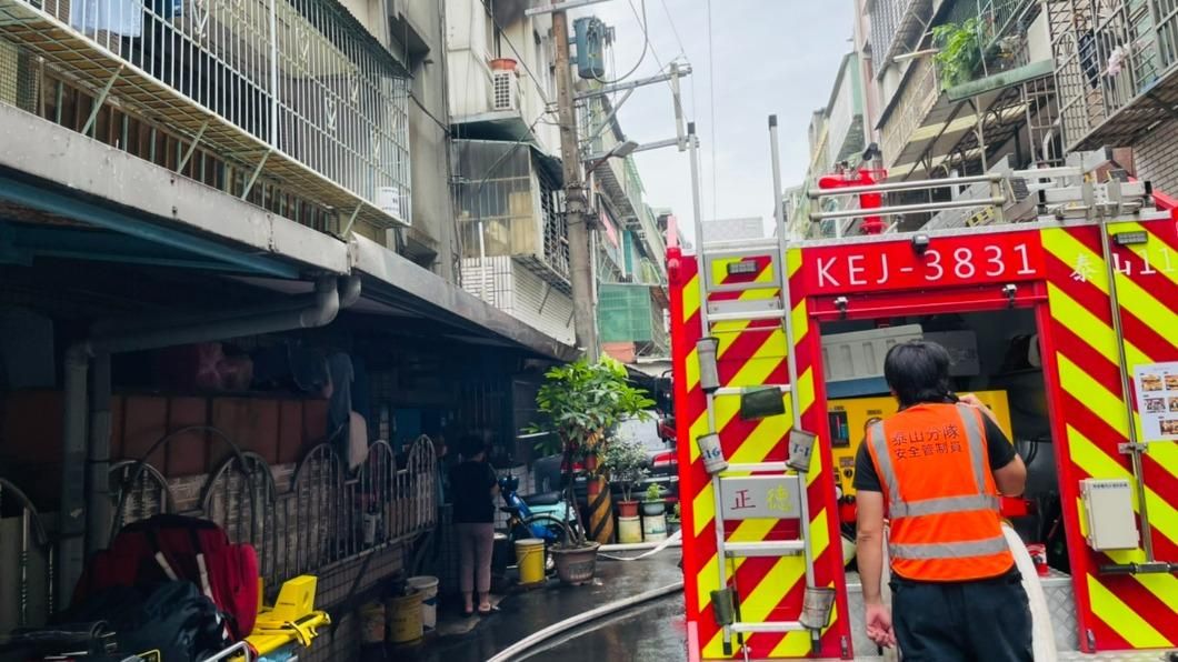 ▲新北市泰山區明志路三段一處公寓，今（10）日上午發生火警，一位女子逃生時從電線杆摔下，疑似右腳骨折送醫治療。（圖／翻攝畫面）