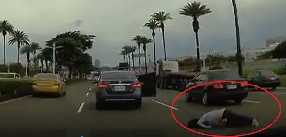 ▲高雄一名女子因與男友吵架，竟在行進中跳車(紅圈處)，倒臥路中。（圖／翻攝臉書記者爆料網）