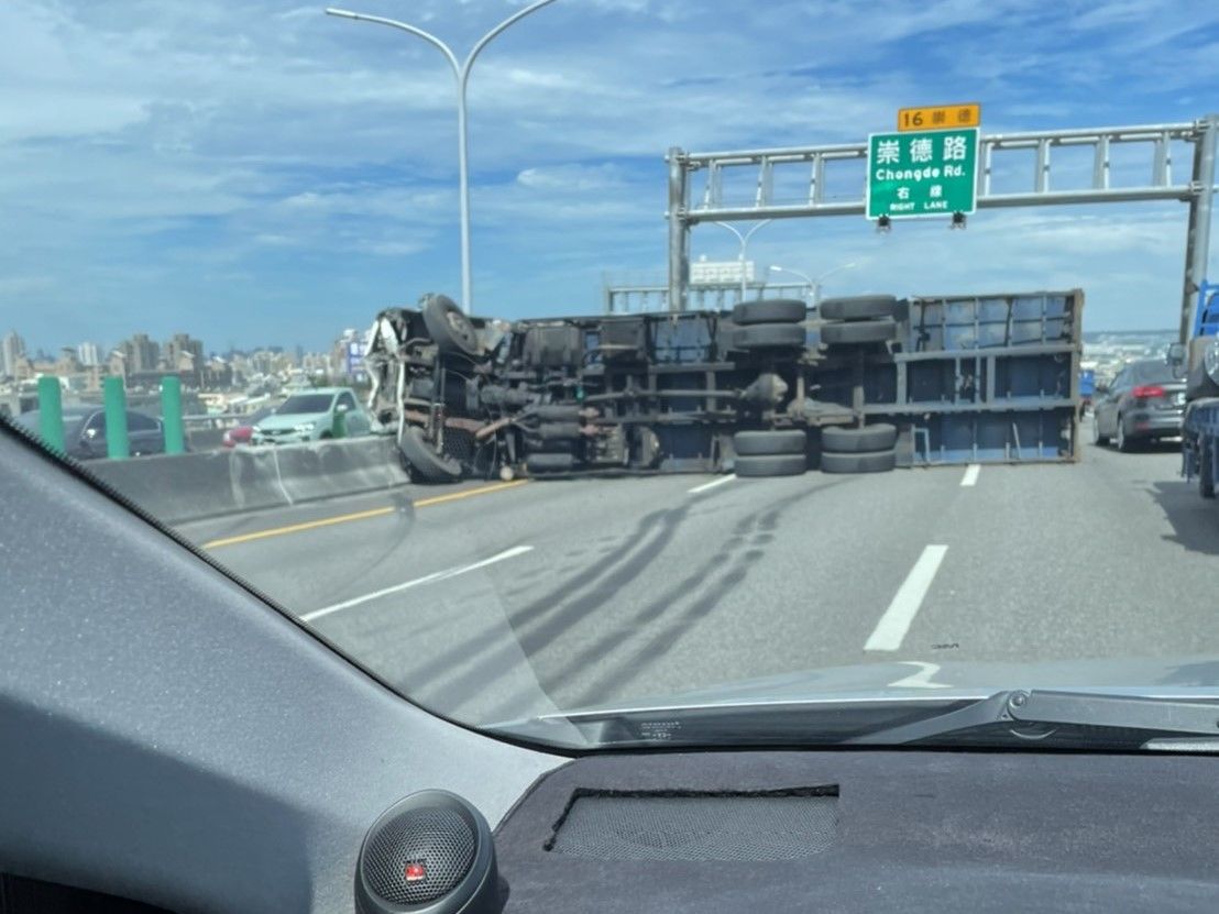 ▲大貨車不明原因翻覆，佔據2線道，一度造成回堵約4公里，2人受傷送醫。（圖／翻攝畫面）
