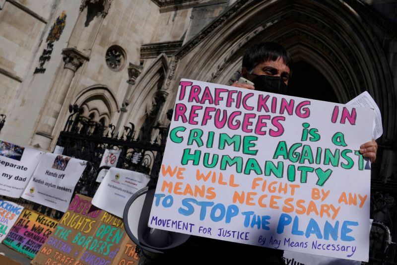 ▲示威群眾手持標語，指控英國遣送難民的行為不人道。（圖／美聯社／達志影像）