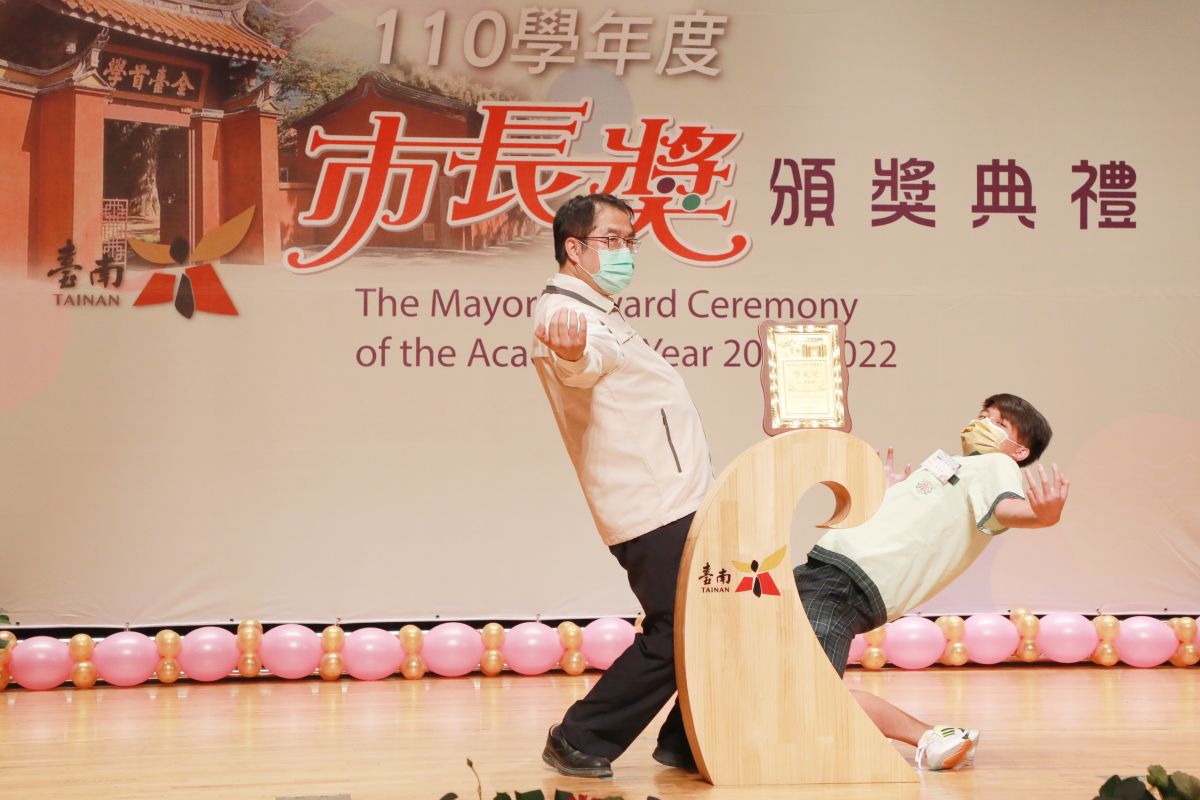 ▲黃偉哲頒發市長獎，配合學生演出高難度動作下腰，笑翻現場家長與學生（圖／台南市政府提供）
