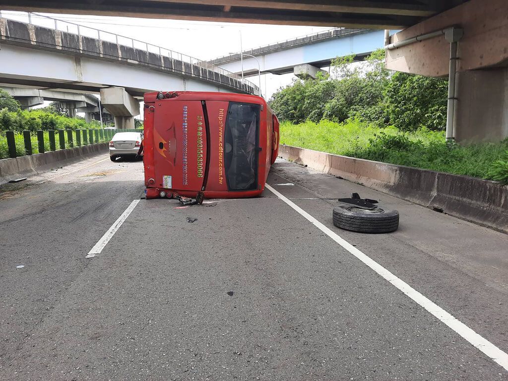 ▲一輛遊覽車21日下午行經新竹台68快速道路9.8K處發生事故翻覆，卡在外側車道及路肩，所幸遊覽車上沒有乘客，司機受傷送醫。（圖／中央社）