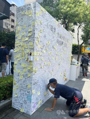 安倍 ▲ 許多民眾無懼高溫炎熱,前往日本台灣交流協會前的留言牆寫下感謝的話。因牆面已寫滿,只能用便利貼浮貼方式或尋找角落空位趴在地上寫。中央社記者黃雅詩攝 111年7月11日